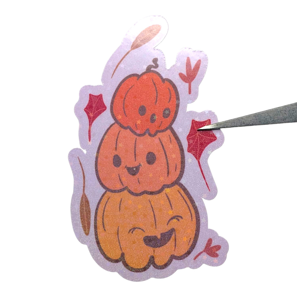 Sticker of three cartoon pumpkins with a lilac border on a white background
