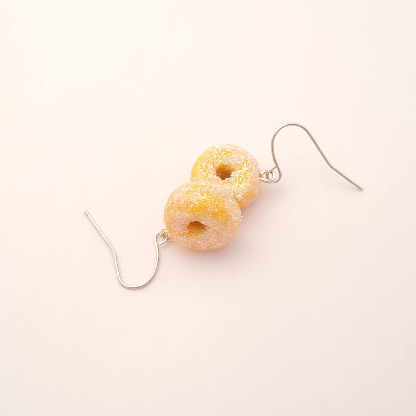 Yellow donut-shaped earrings on a white background