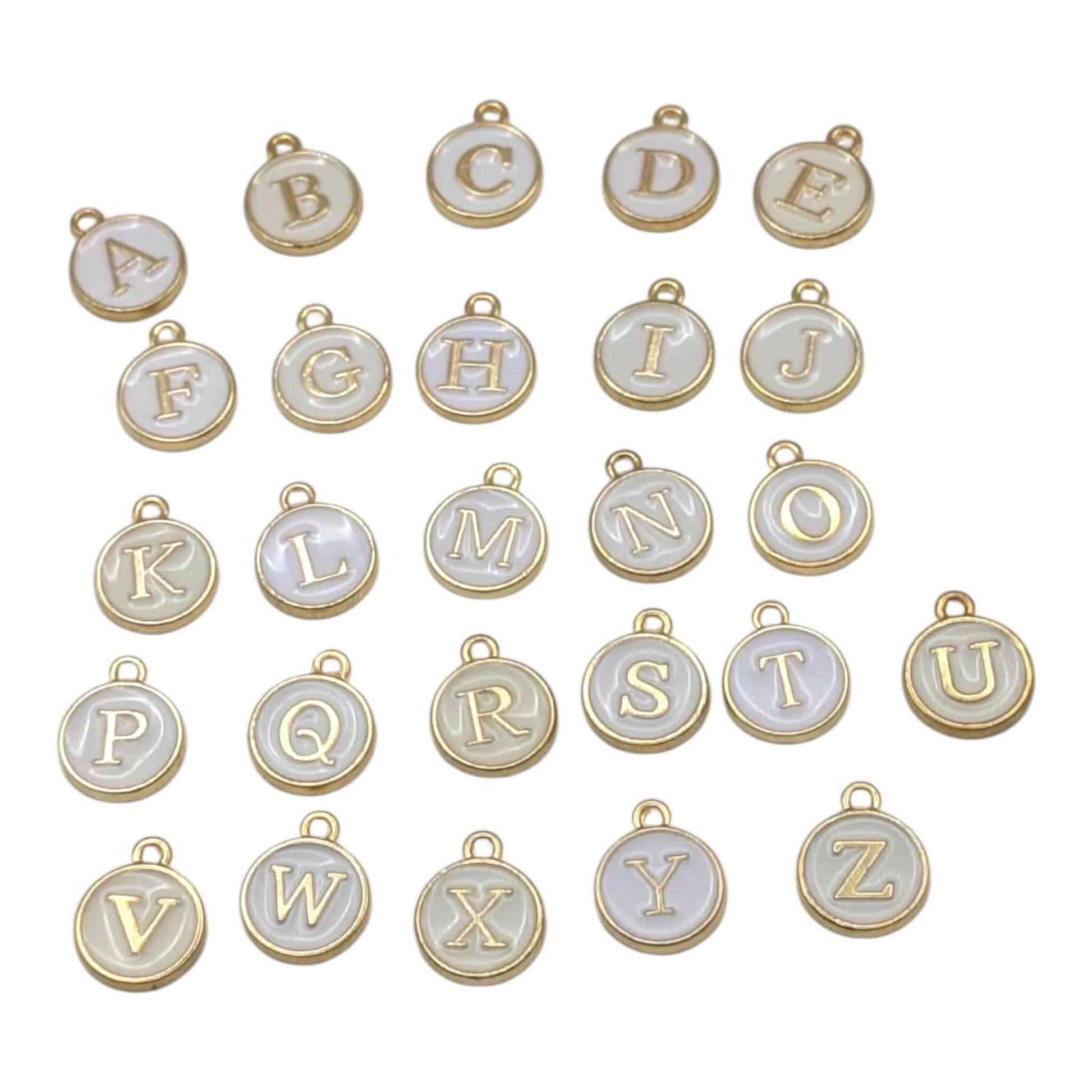 Alphabet letter charms with gold and white finish on a white background