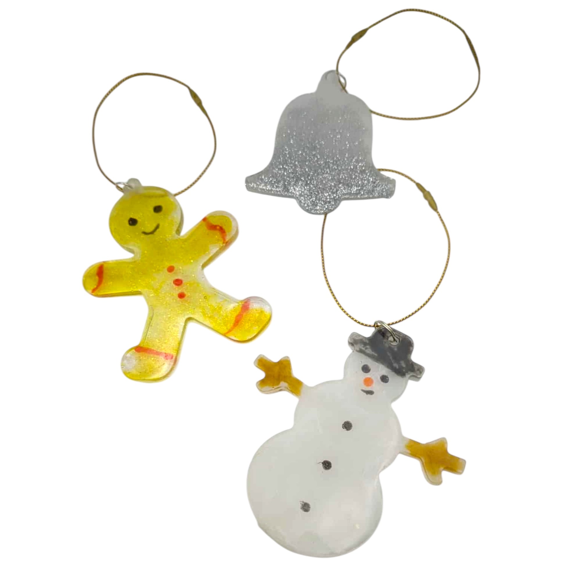 Three Christmas ornaments including a gingerbread man, bell, and snowman on a white background.
