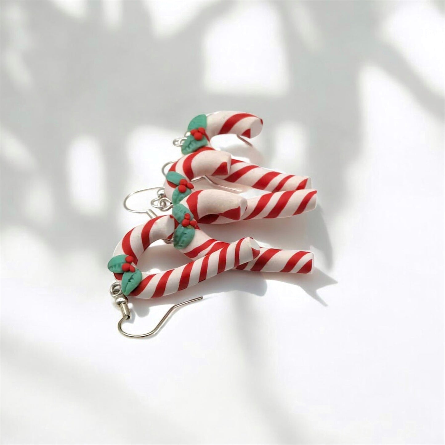 Candy cane-shaped earrings on a white background