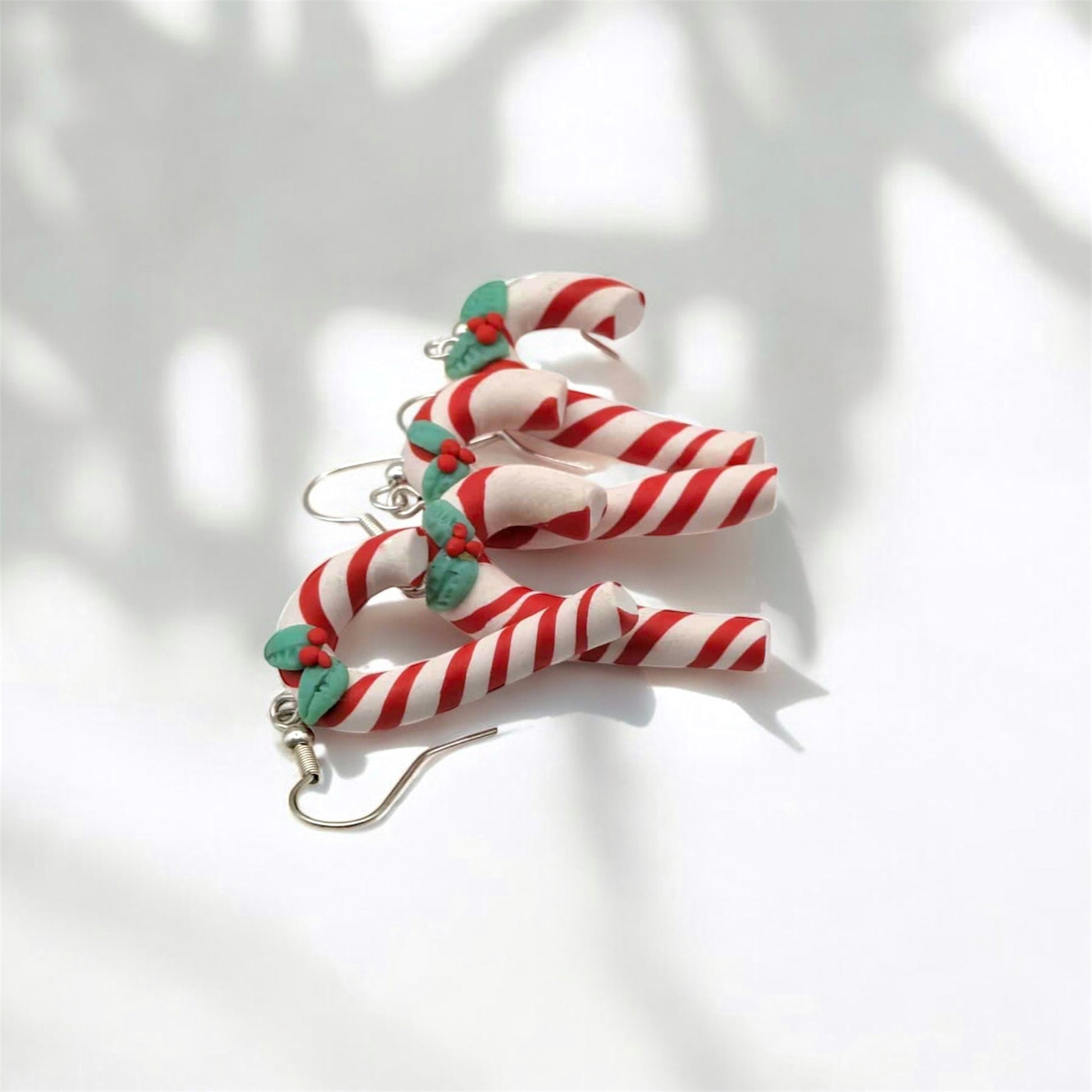 Candy cane-shaped earrings on a white background