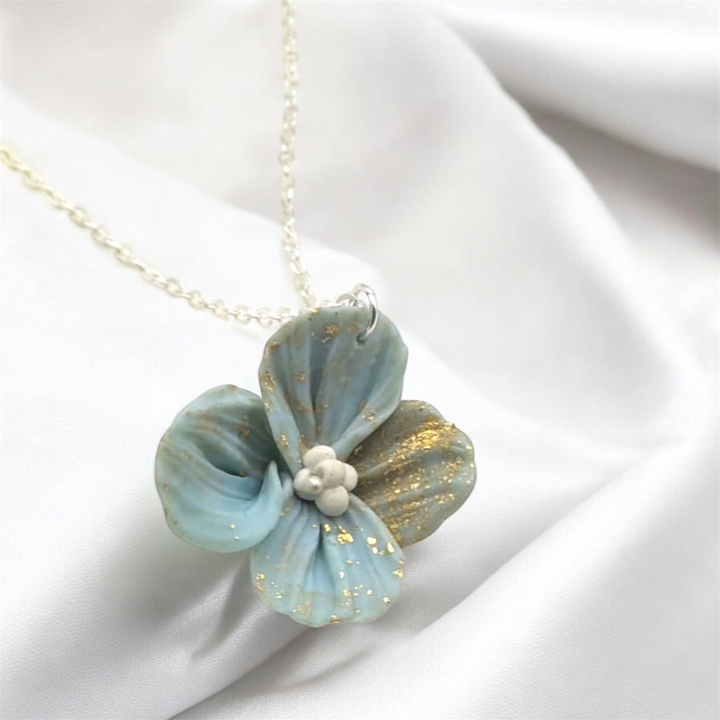 Floral pendant necklace on a white fabric background