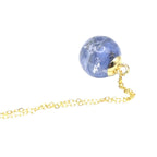 Gold necklace with a blue floral globe on a white background