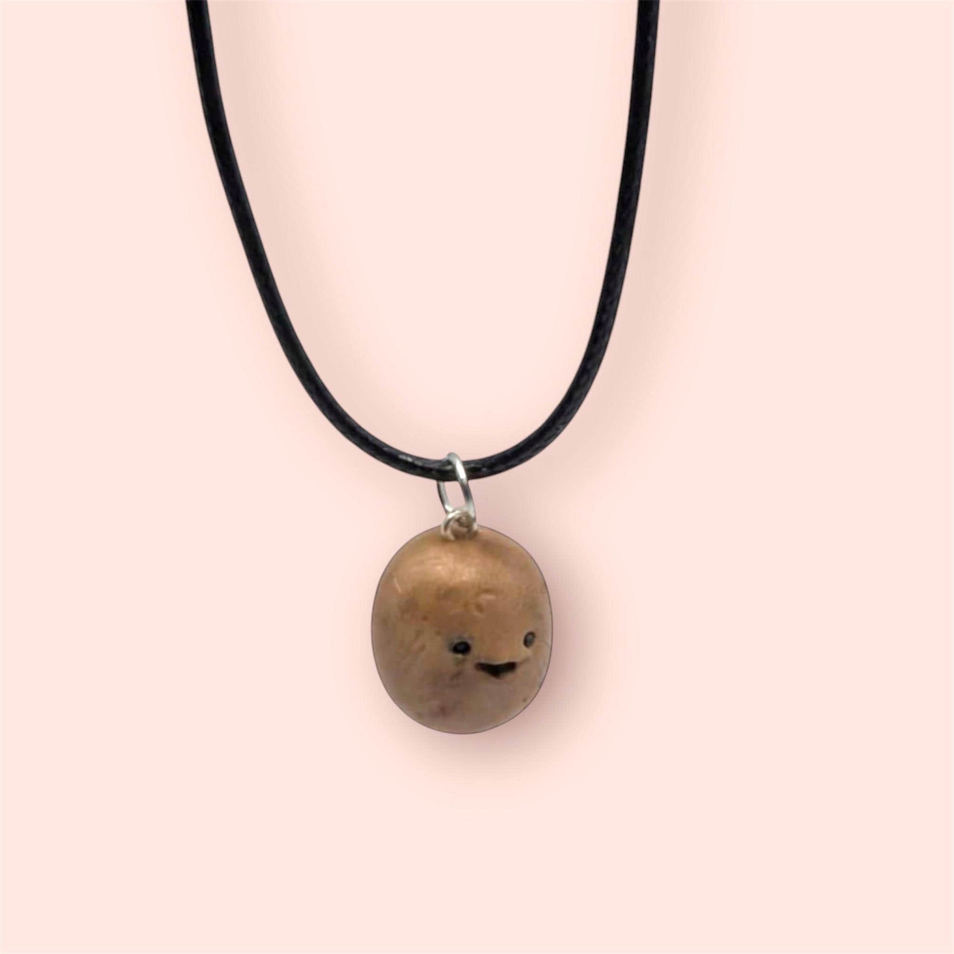 Necklace with a round potato pendant on a plain background