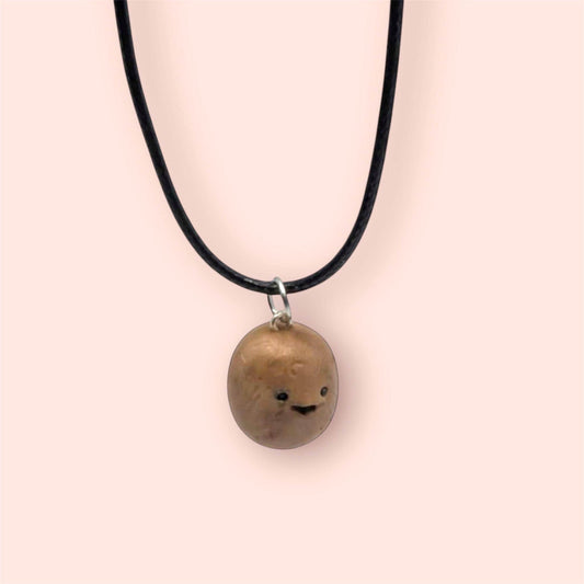 Necklace with a round potato pendant on a plain background