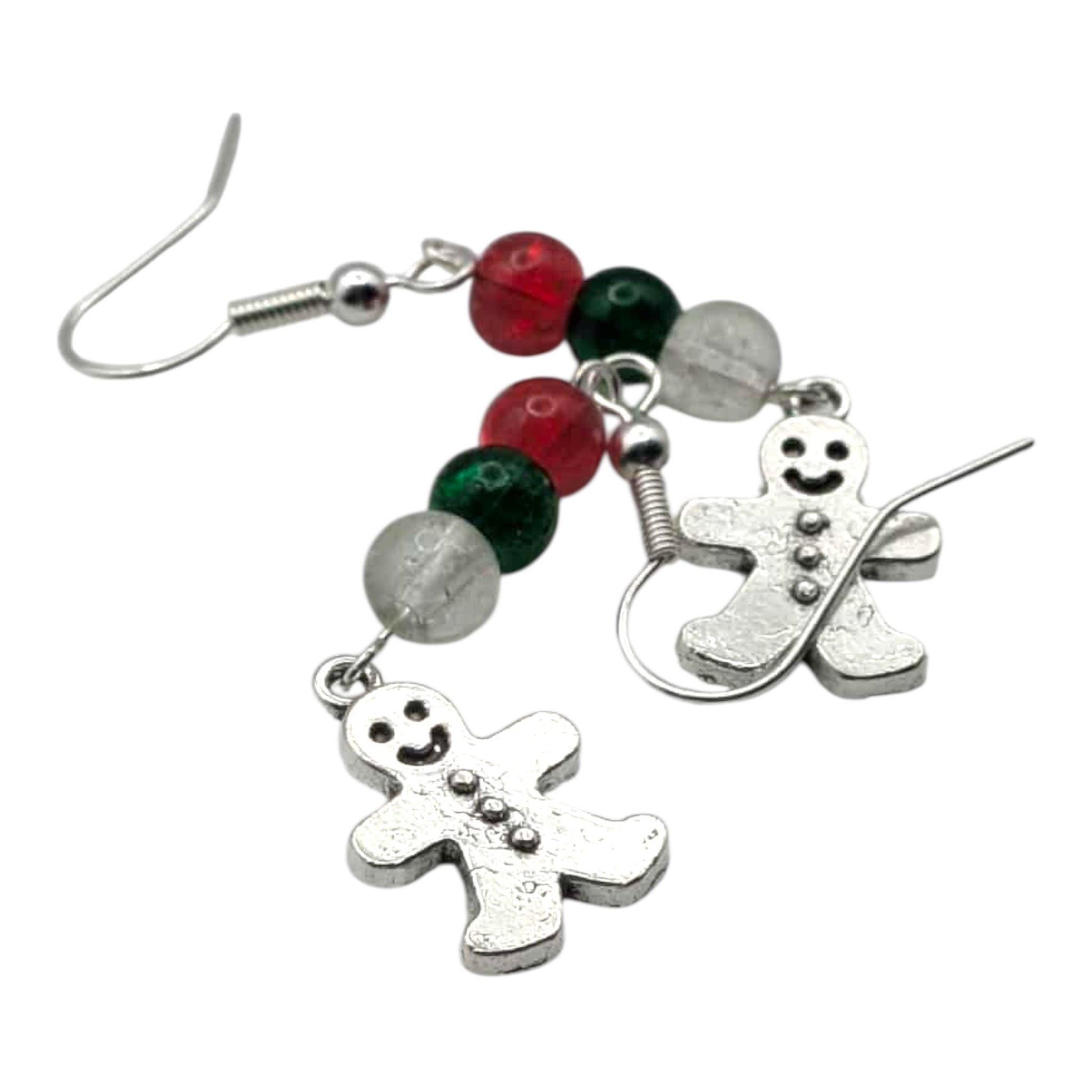 Gingerbread man earrings with red, green, and silver beads on a white background