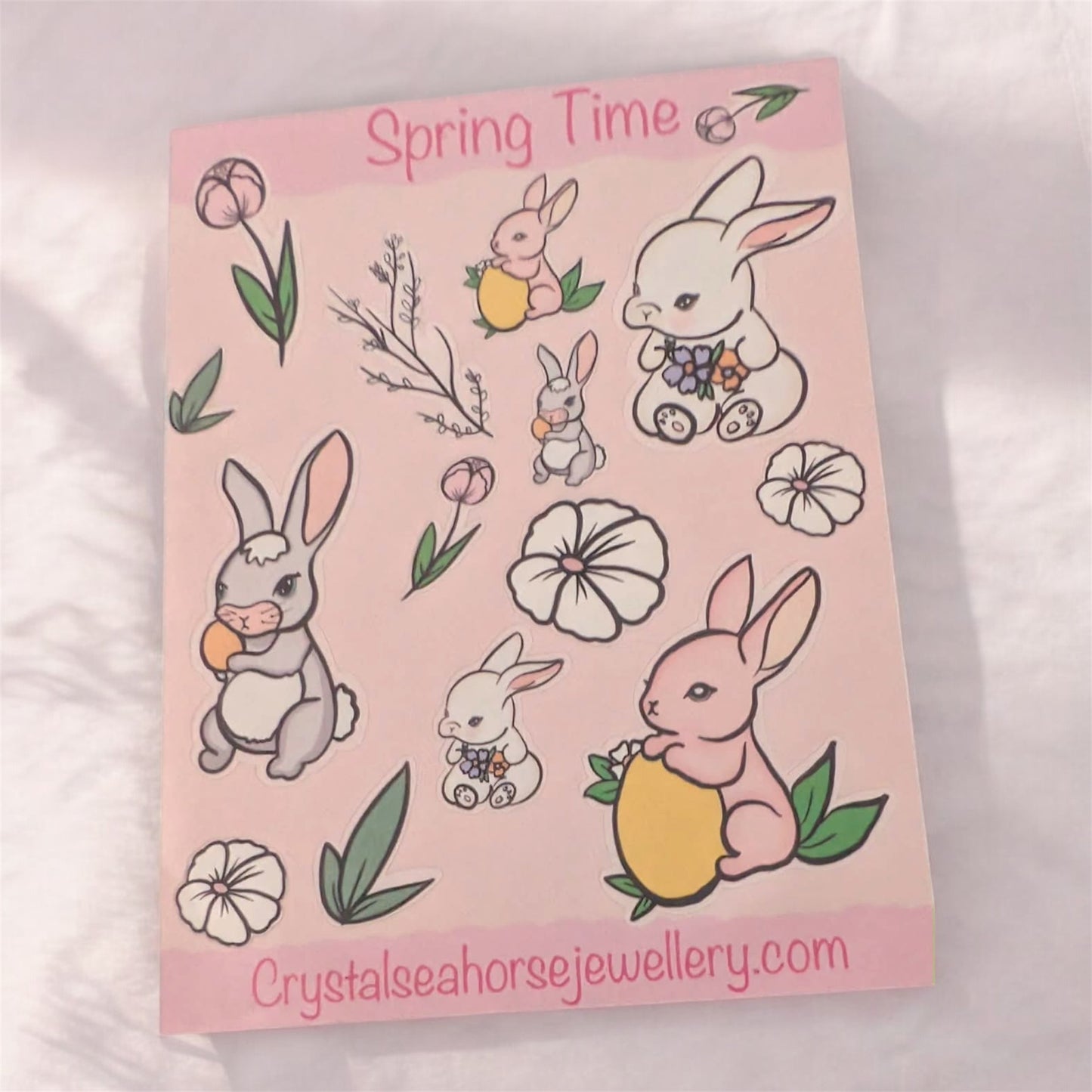 Sheet of spring-themed stickers with cartoon bunnies and flowers on a pink background.