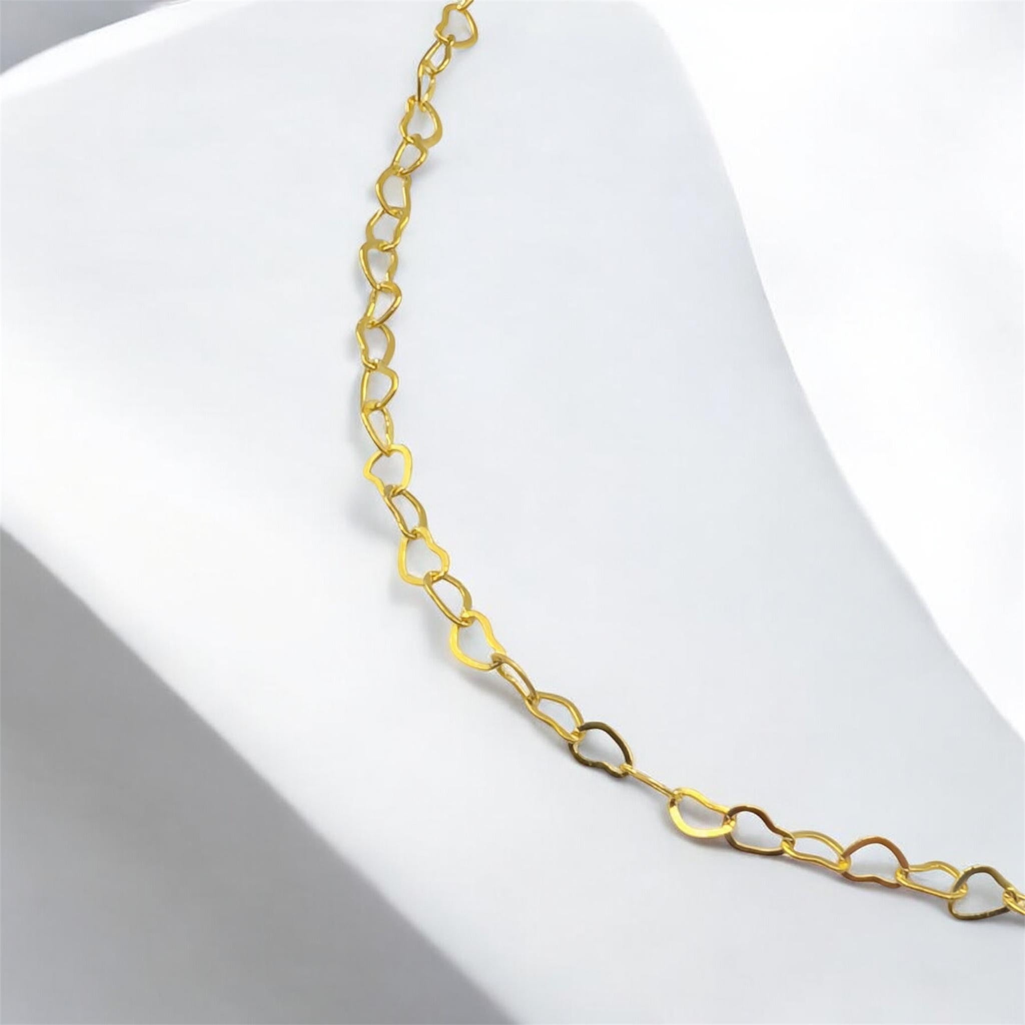 Close up of gold heart chain necklace links