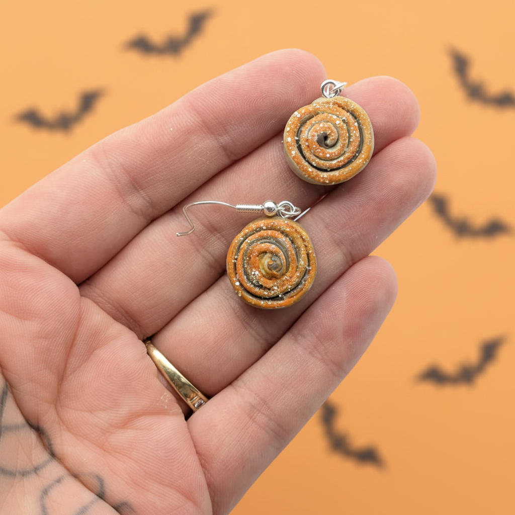 Halloween Cinnamon Roll Earrings Hand Shot