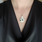 Ghost pendant necklace worn on neck with silver chain 