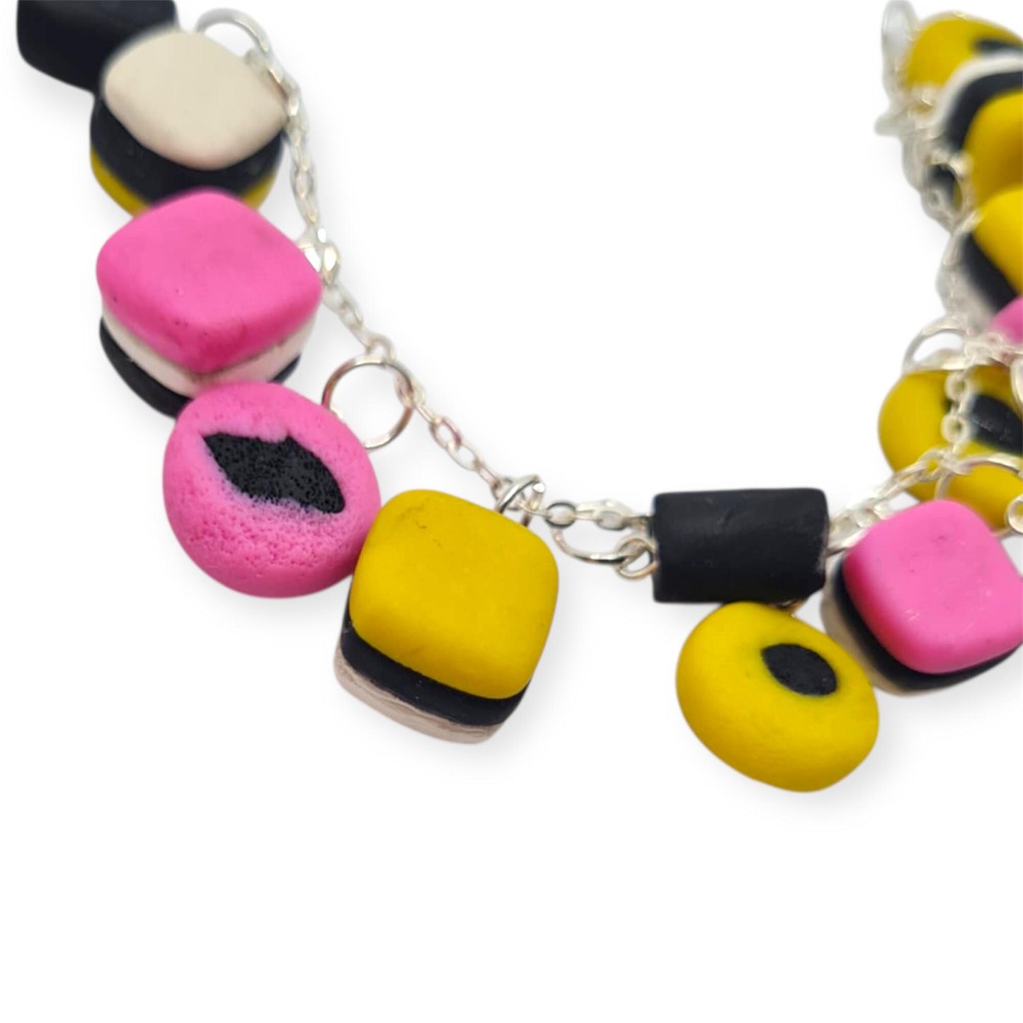 Colorful polymer clay beads on a silver chain against a white background