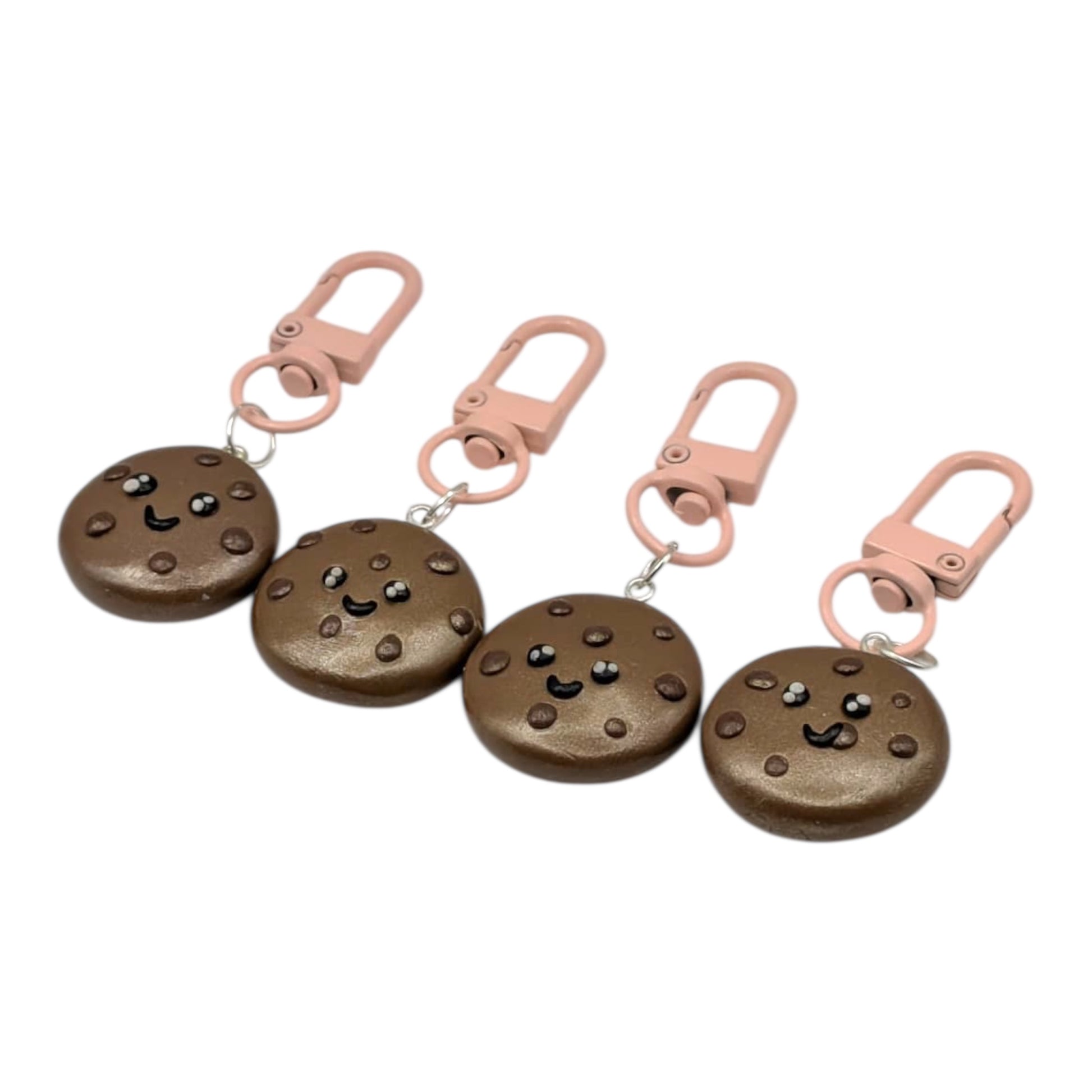 Four cookie-shaped keychains with pink clips on a white background