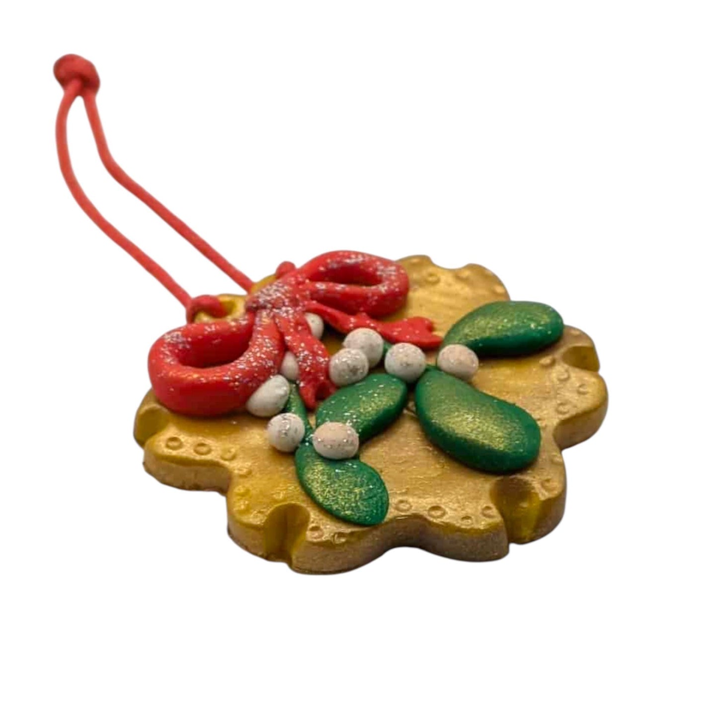 Decorative Christmas ornament with red bow, green leaves, and white berries on a white background