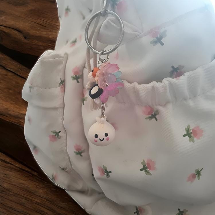 Keychain with cartoon character attached to a floral-patterned fabric background