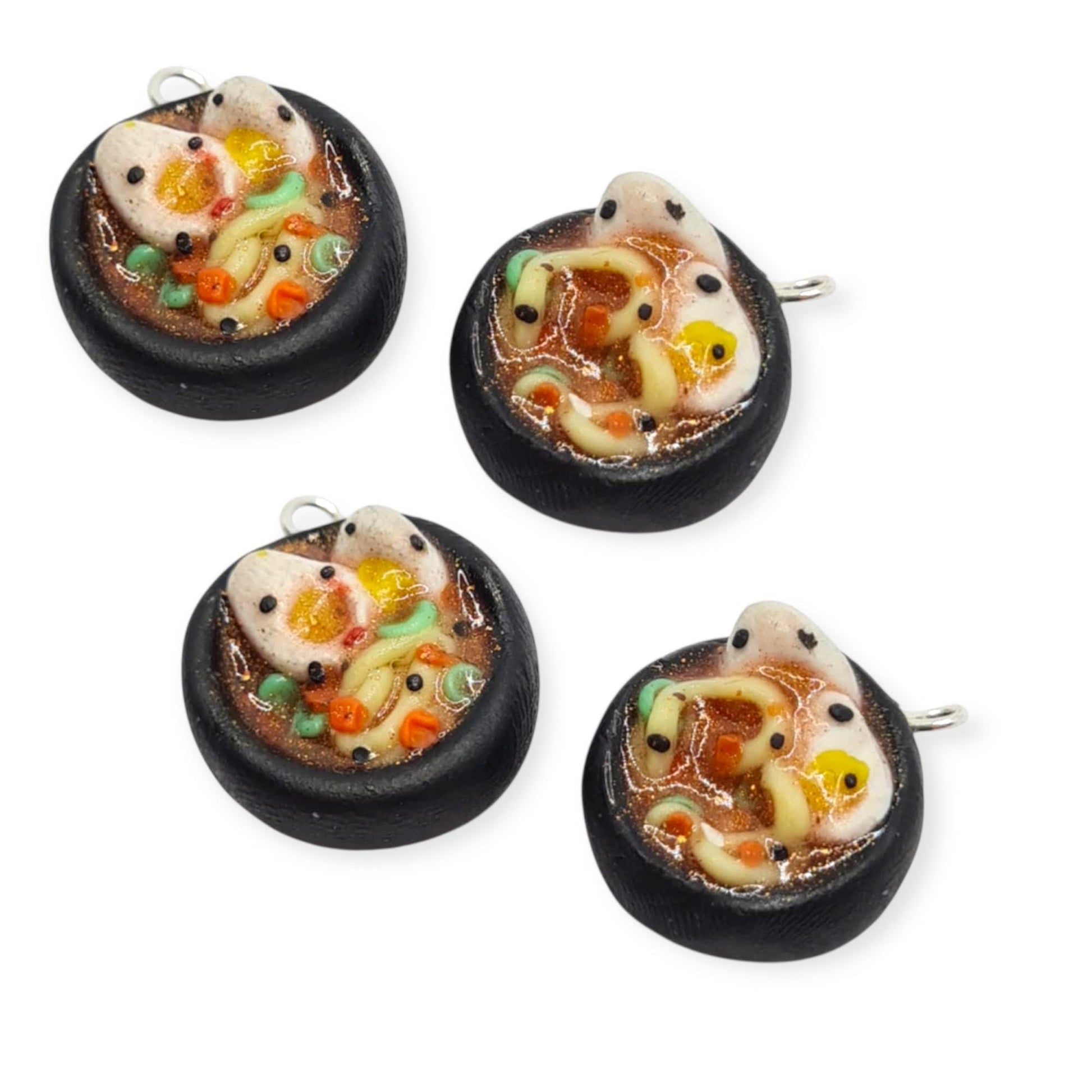 Four miniature soup charms on a white background