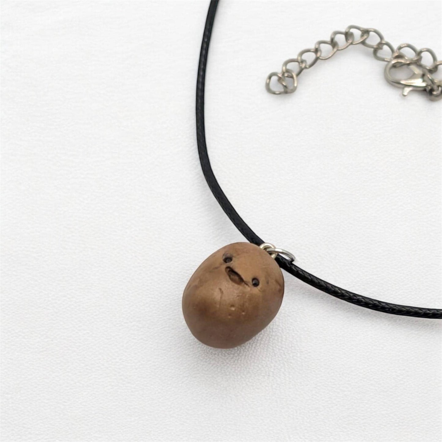 Necklace with a brown potato pendant on a white background