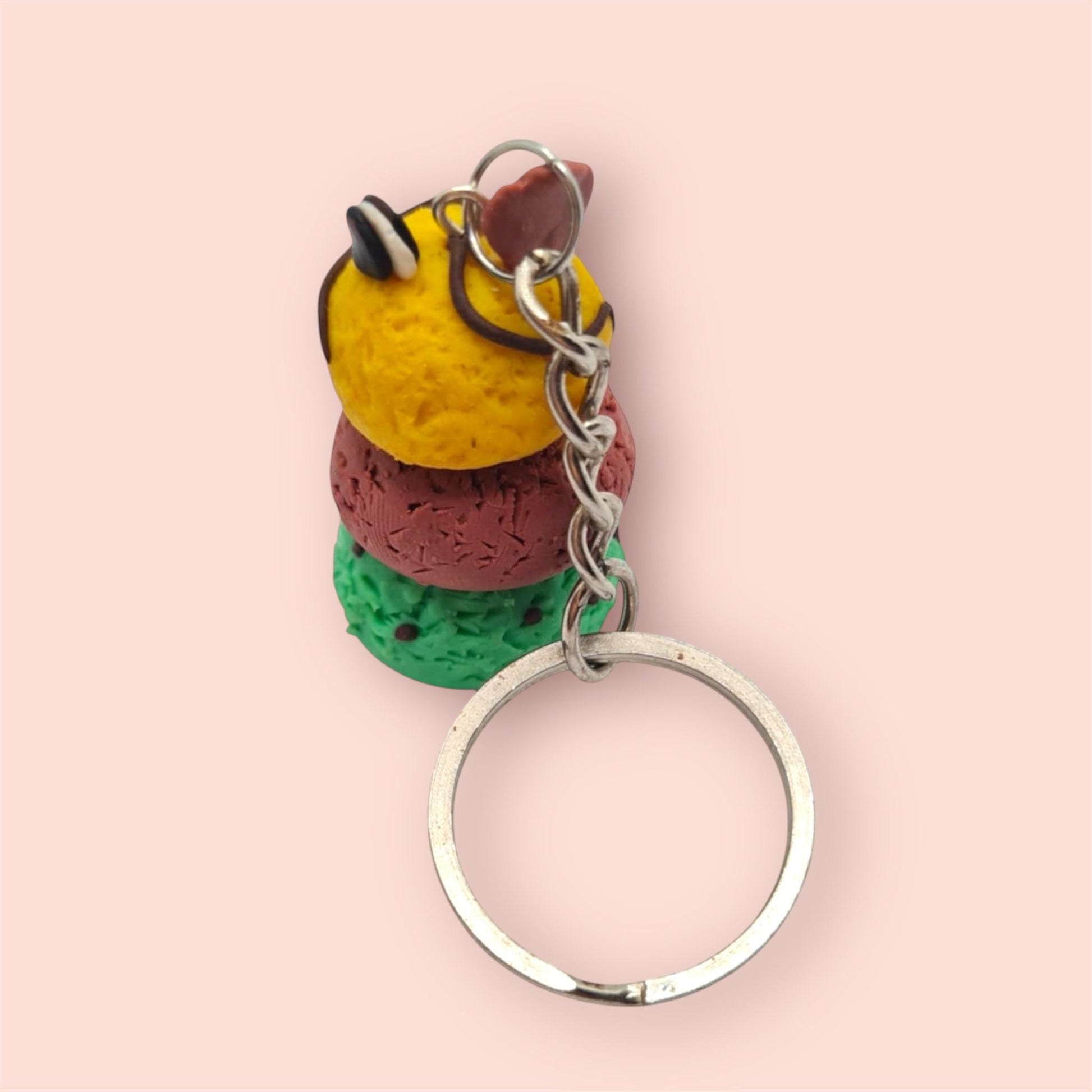 Colorful keychain with three spherical beads on a pink background
