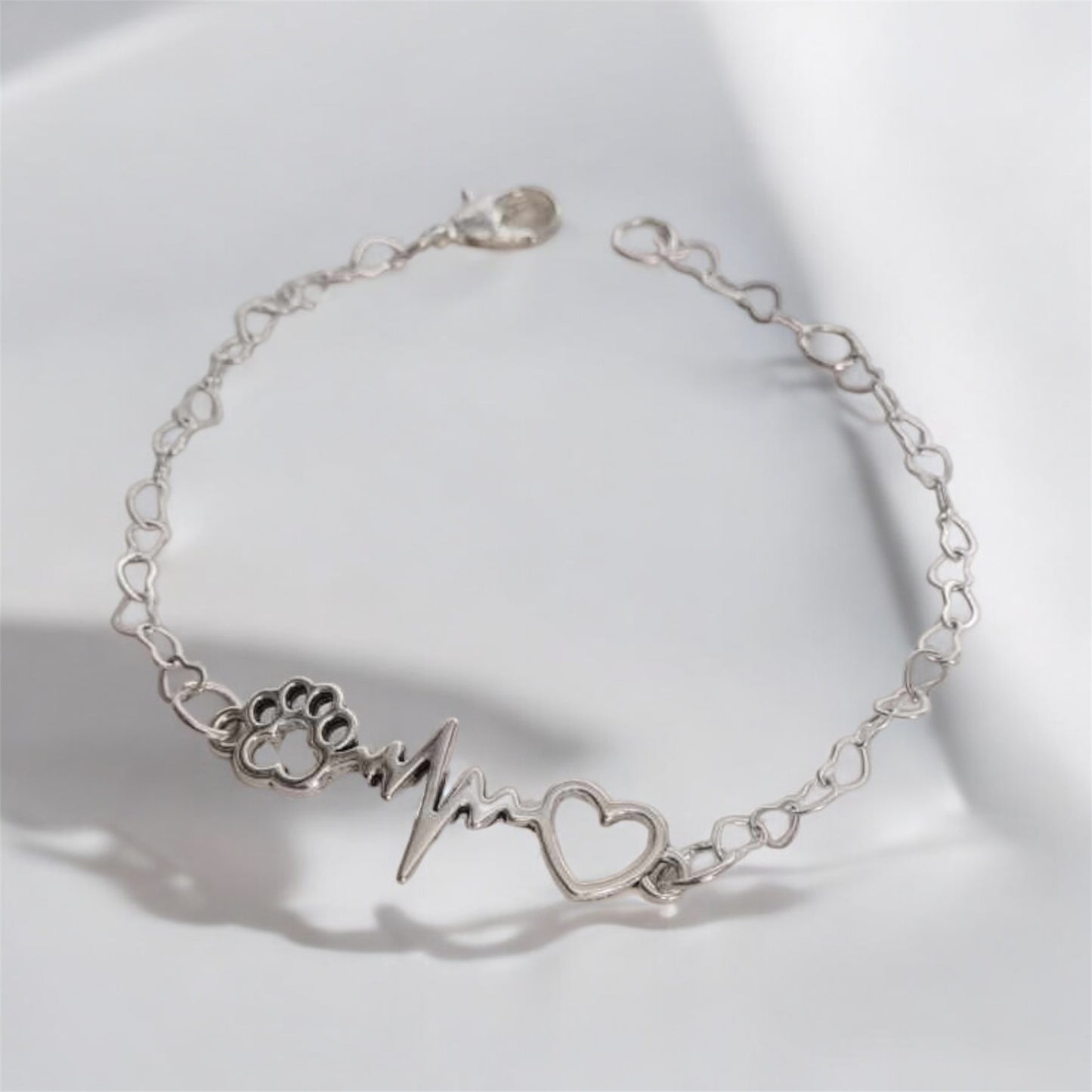 Paw bracelet featuring a heart charm and heartbeat design, perfect for dog lovers.