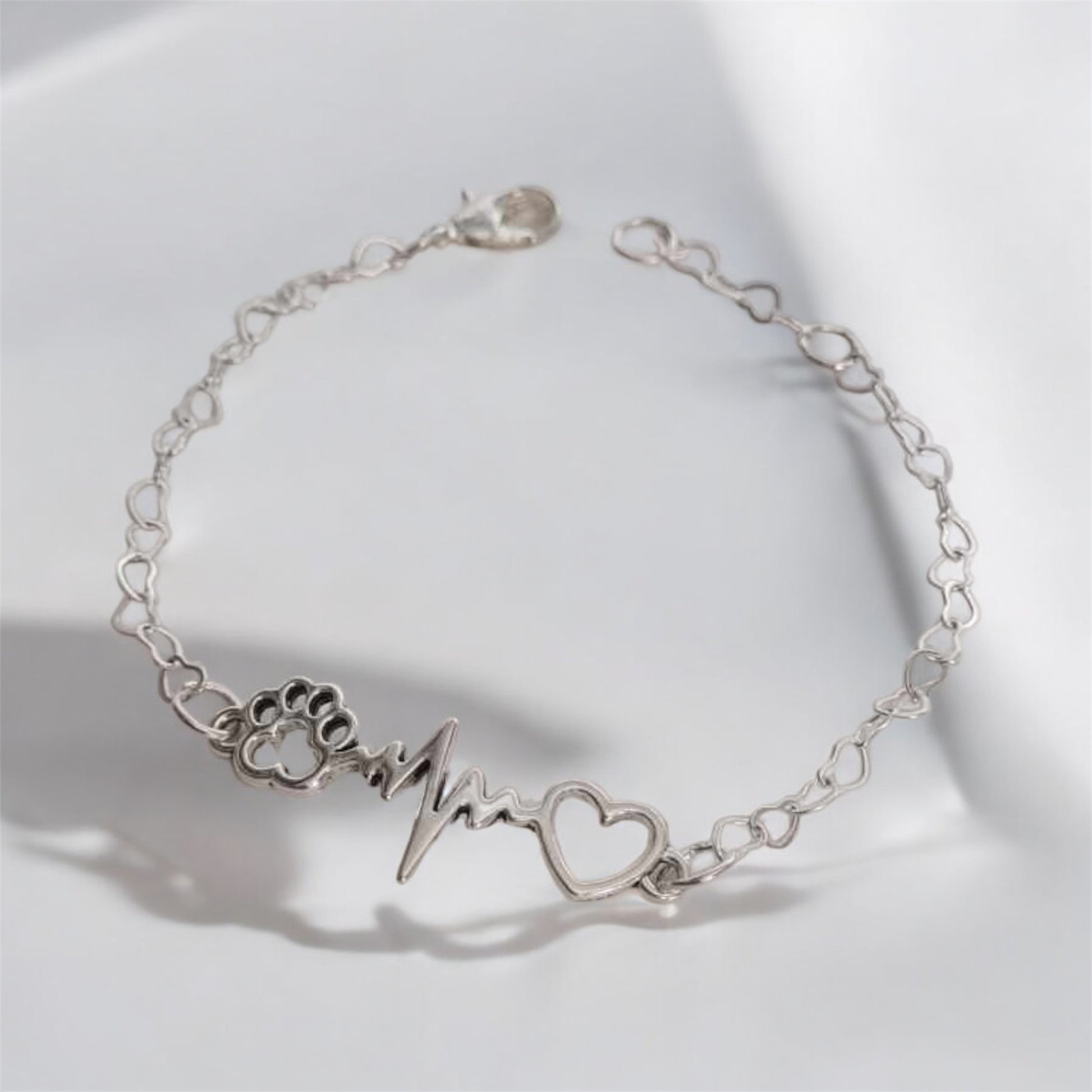 Paw bracelet featuring a heart charm and heartbeat design, perfect for dog lovers.
