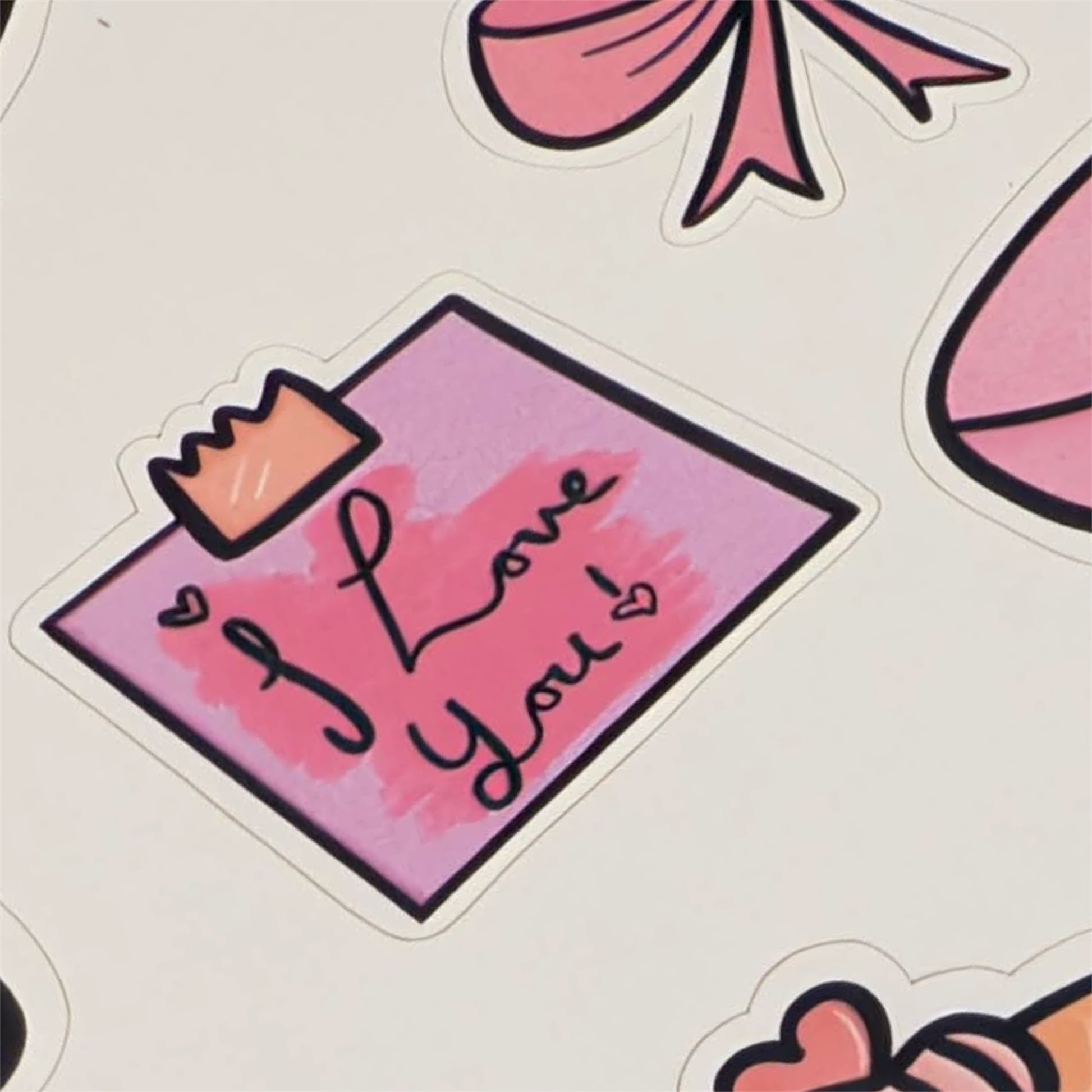 Sticker with 'I Love You' text on a pink background with decorative elements.