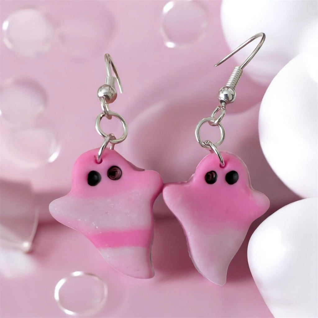 Pink ghost-shaped earrings on a pink background
