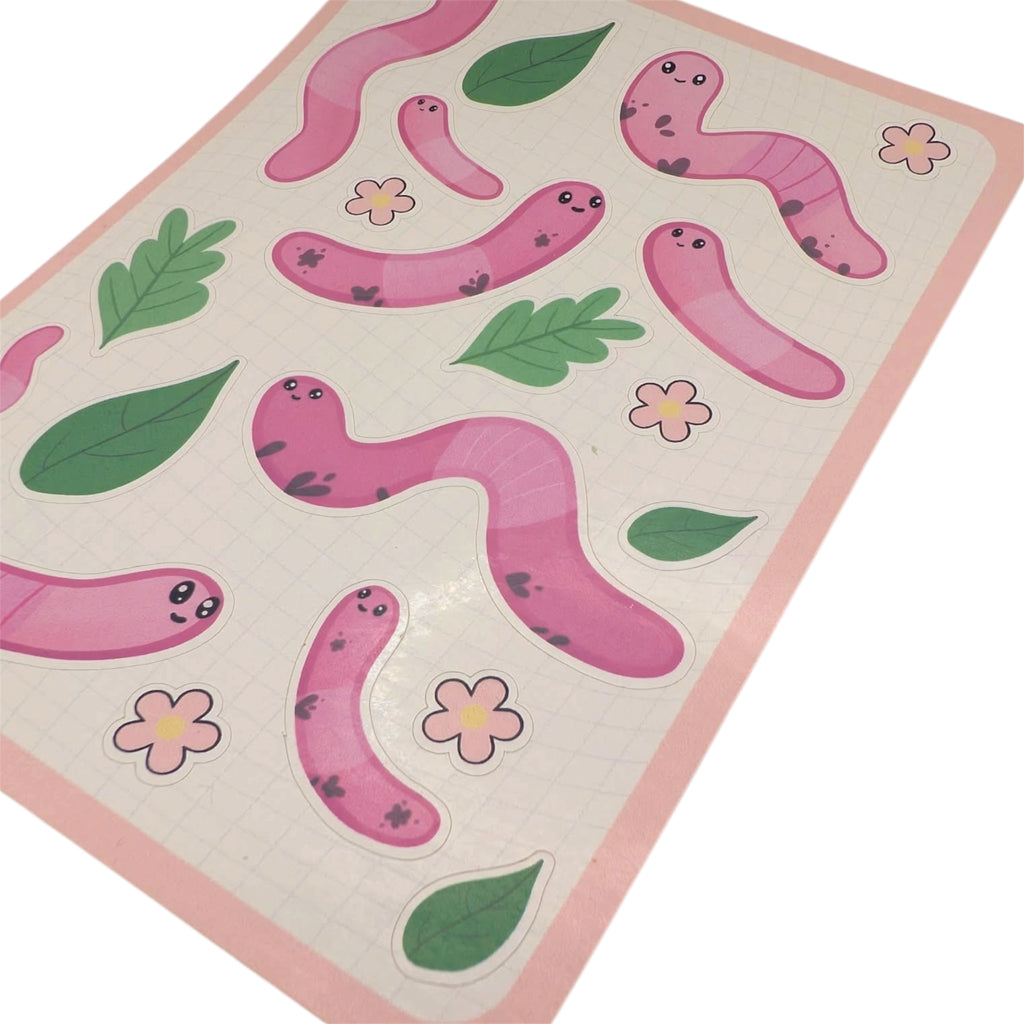 Close up of pink worm sticker sheet with cartoon earthworms, leaves and flowers shown on a white background 