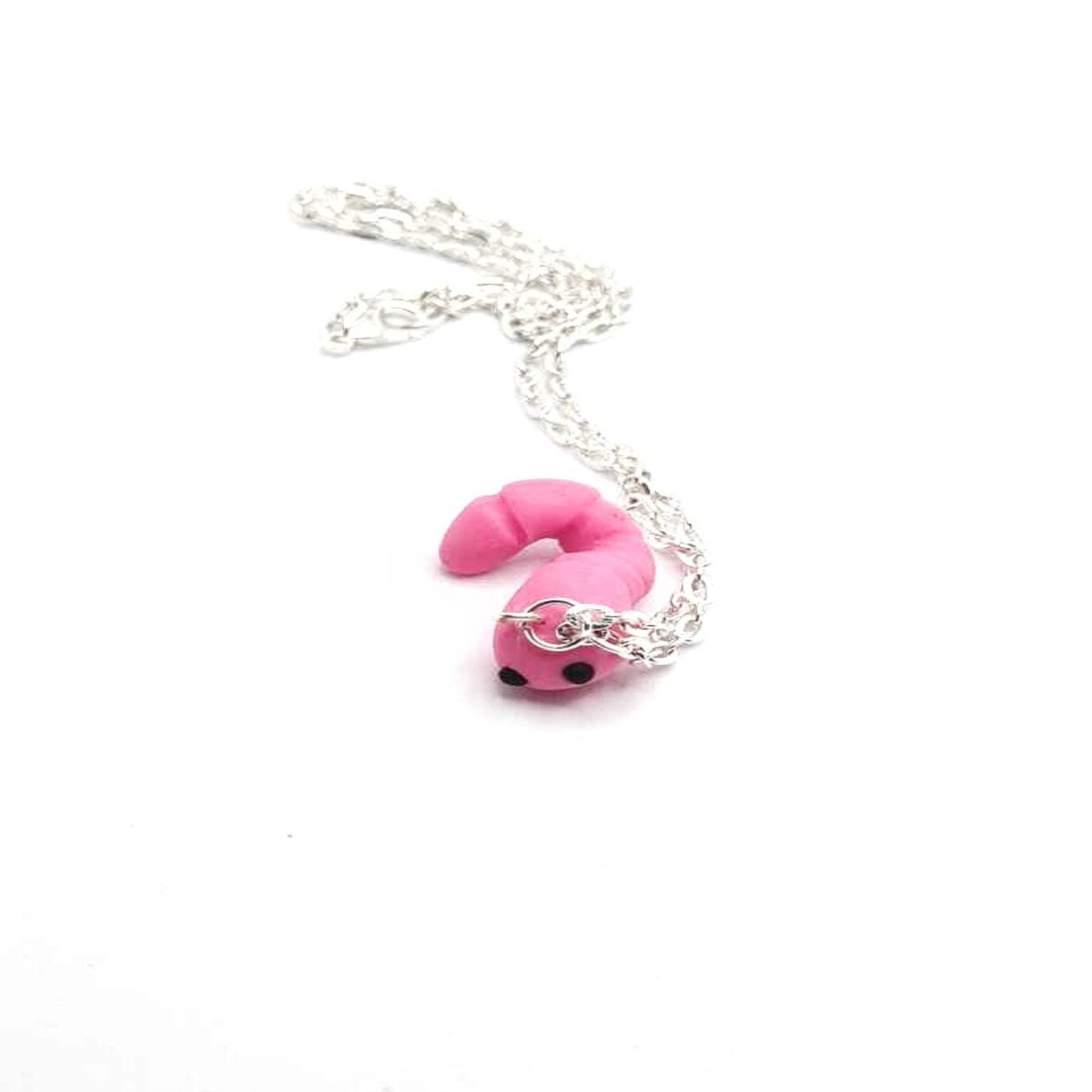 Pink worm-shaped pendant on a silver chain against a white background