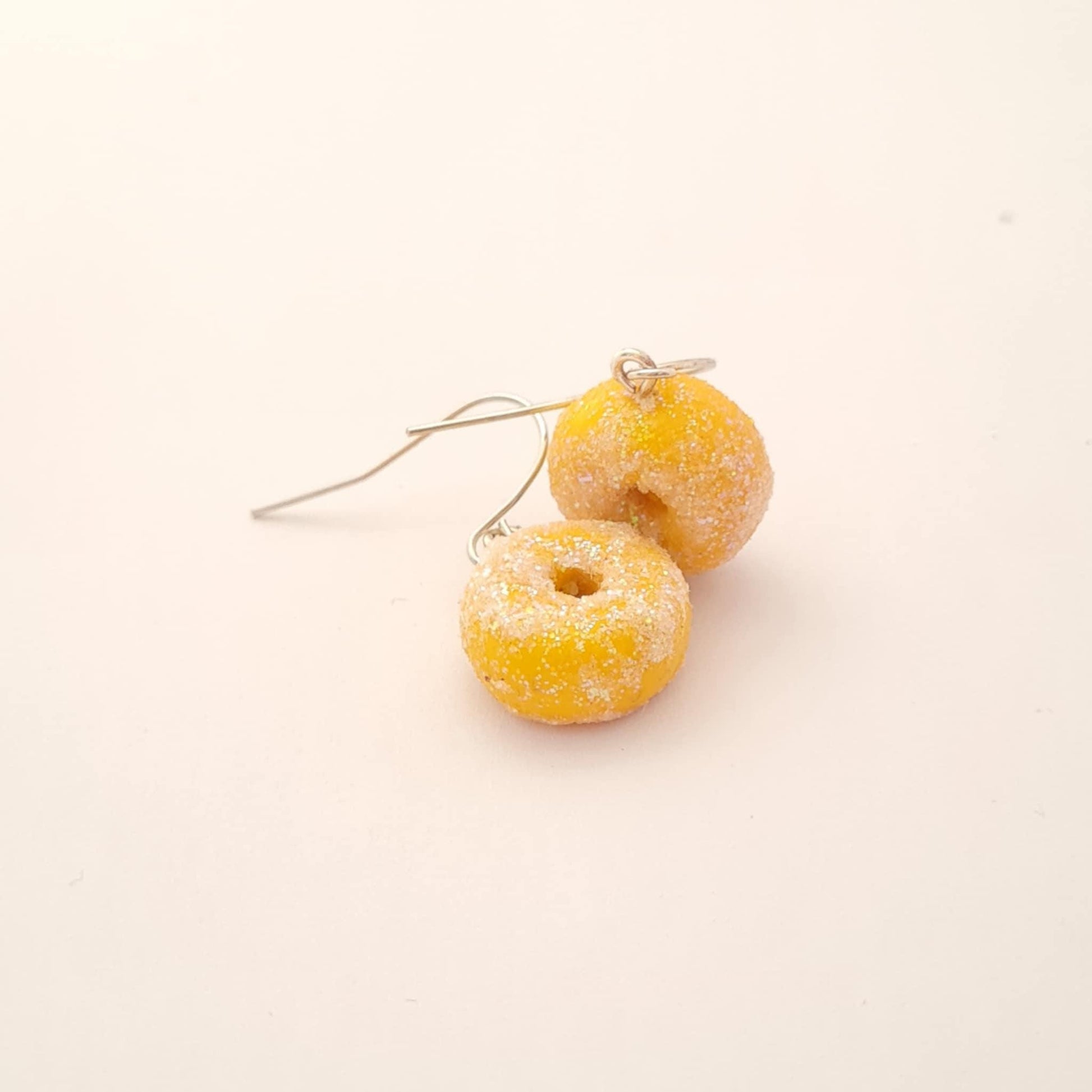Donut-shaped earrings on a light beige background