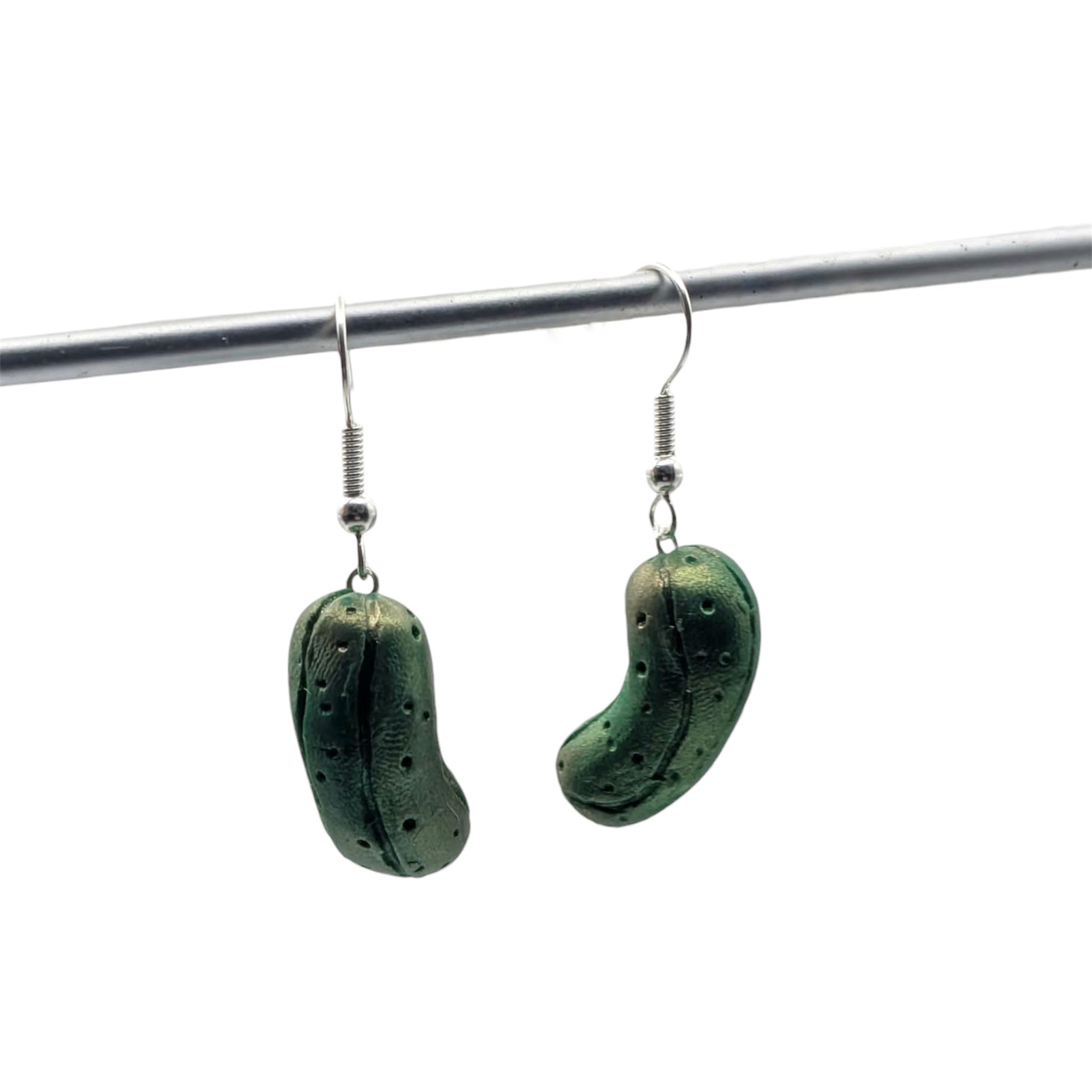 Green pickle earrings hanging on silver plated ear wires, handmade polymer clay jewellery UK