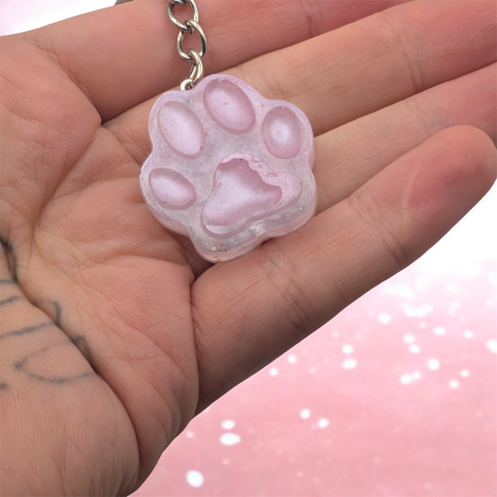 Pink handmade resin paw print keychain held in hand, cute gift for pet lovers