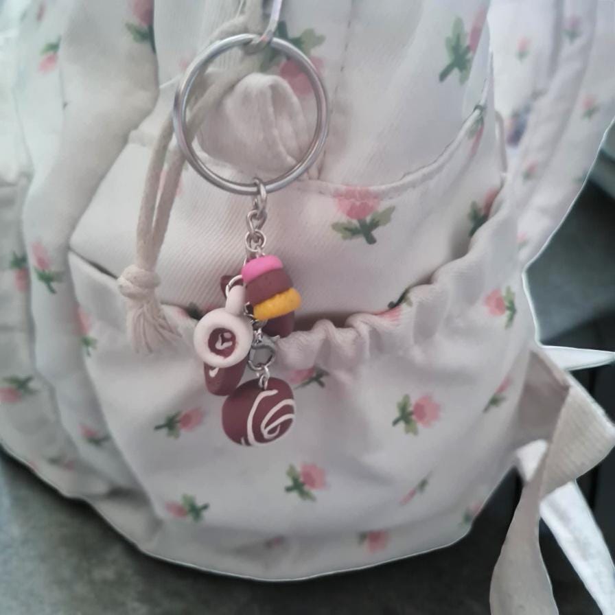 Keychain with colorful charms attached to a floral-patterned bag.