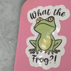 Sticker with a frog graphic and text 'What the Frog?!' on a pink background.