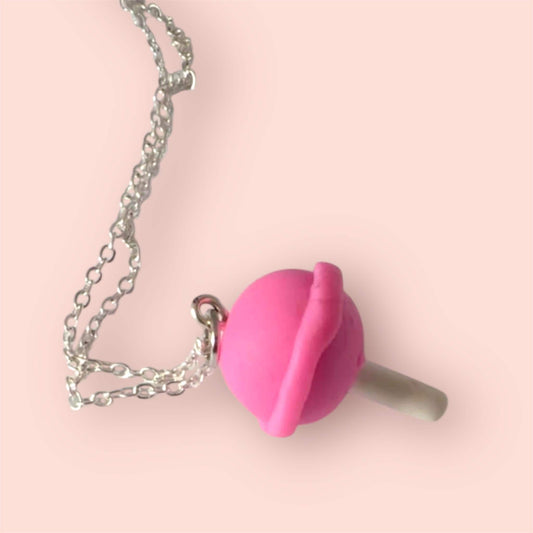 Pink lollipop shaped charm on a silver chain against a pink background