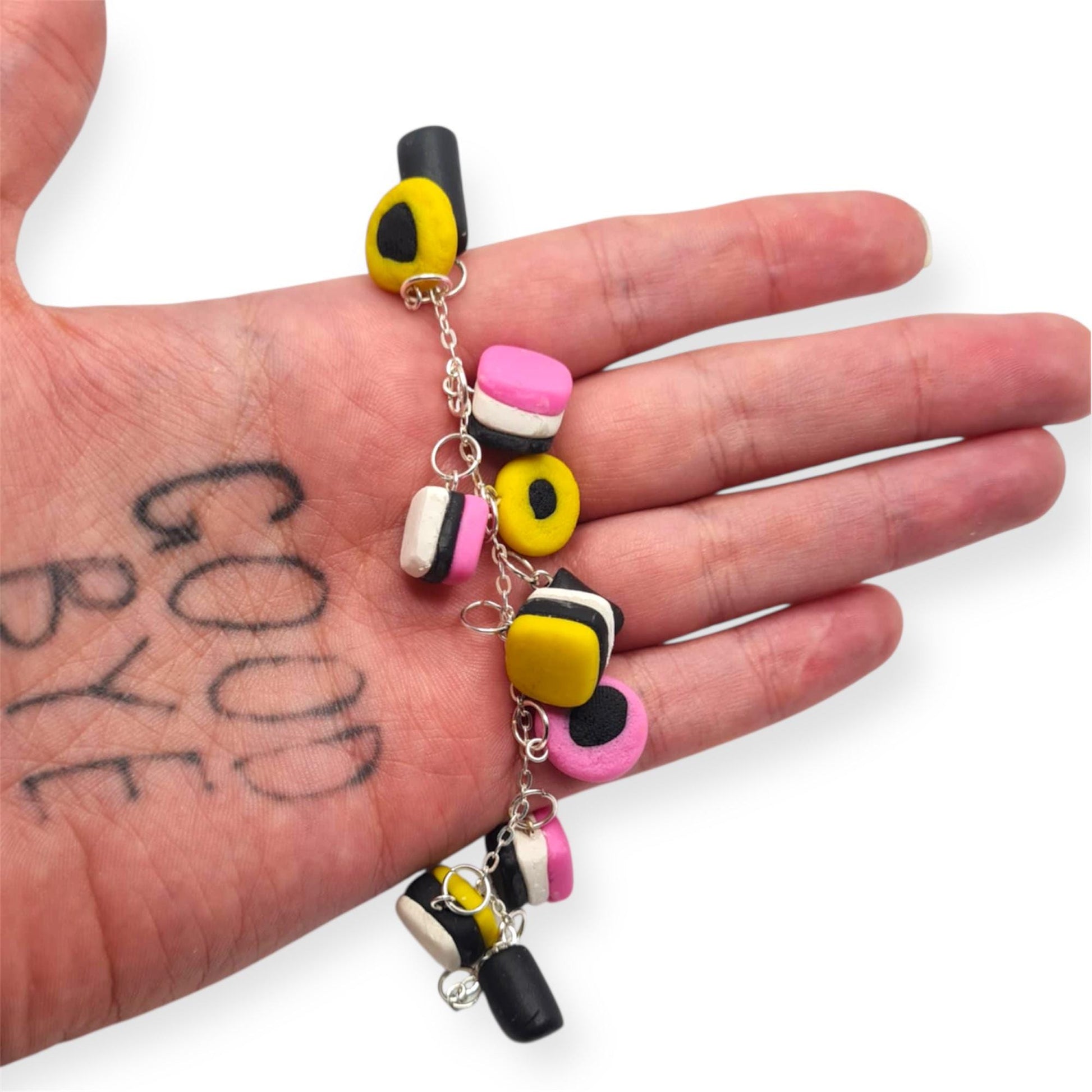 Colorful bracelet held in a hand with 'GOOD BYE' tattoo
