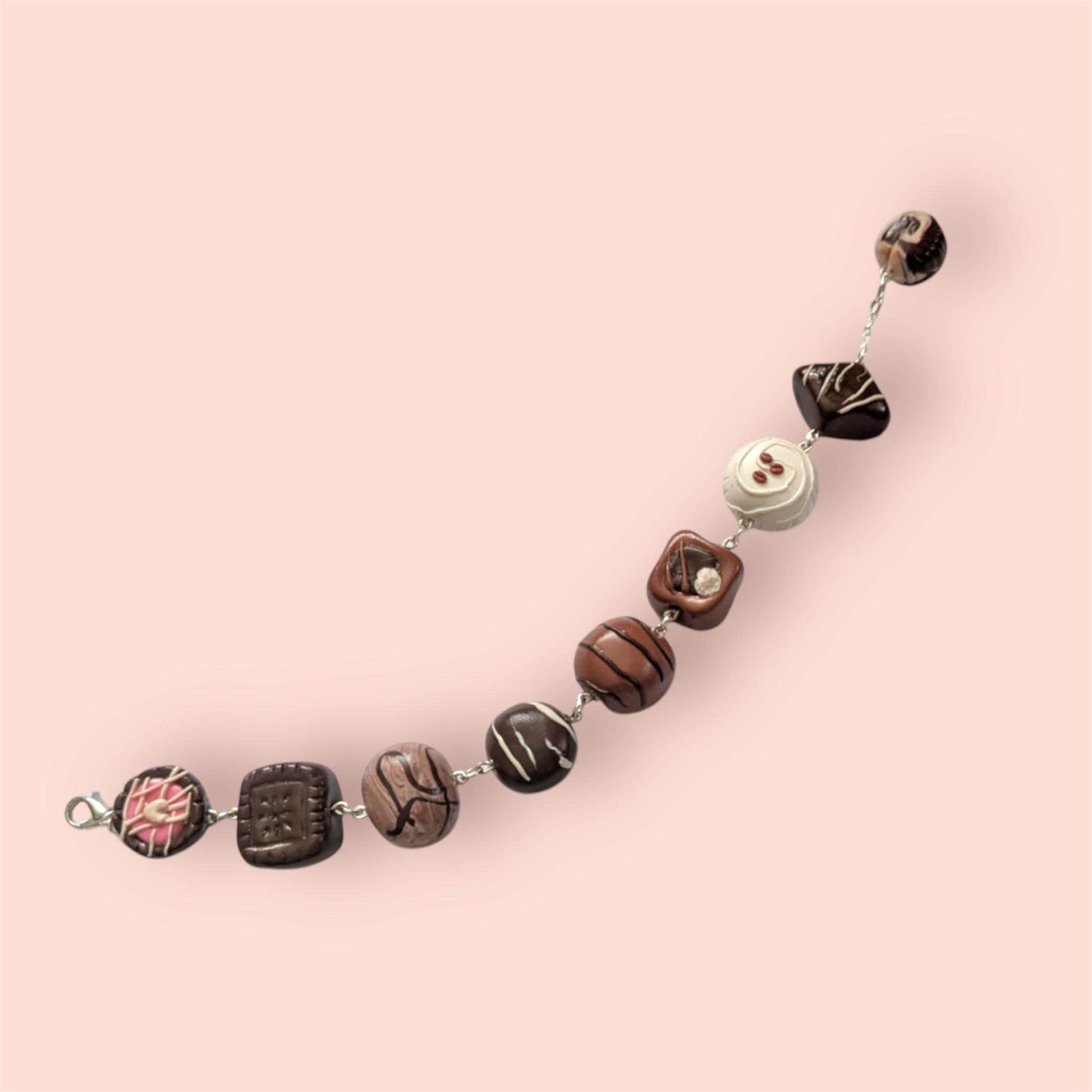 Chocolate bracelet with decorative elements on a pink background