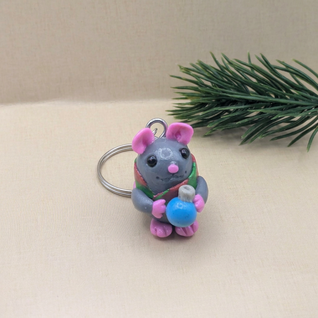 Christmas mouse keyring holding a blue ornament, a cute and festive gift for the holidays.