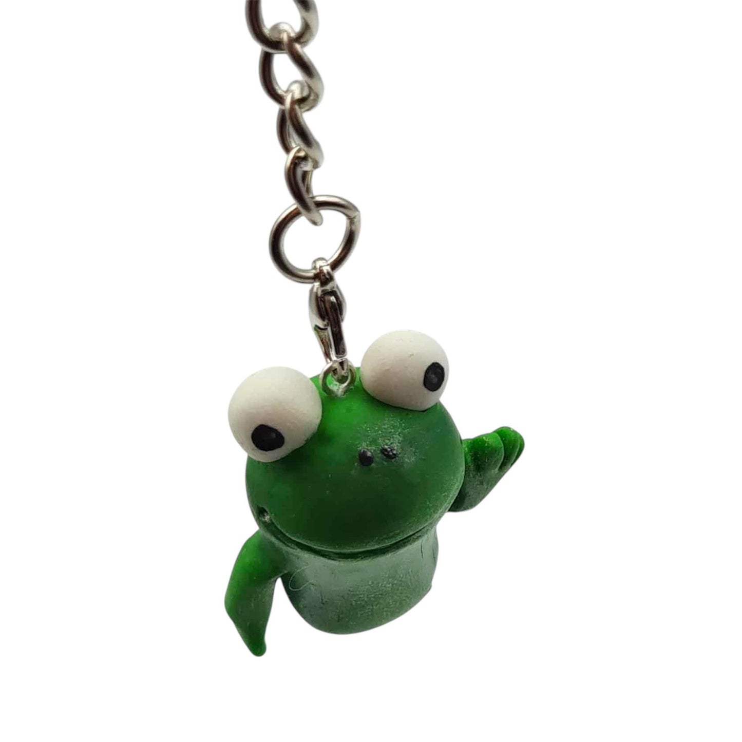 Green frog-shaped keychain with googly eyes on a white background