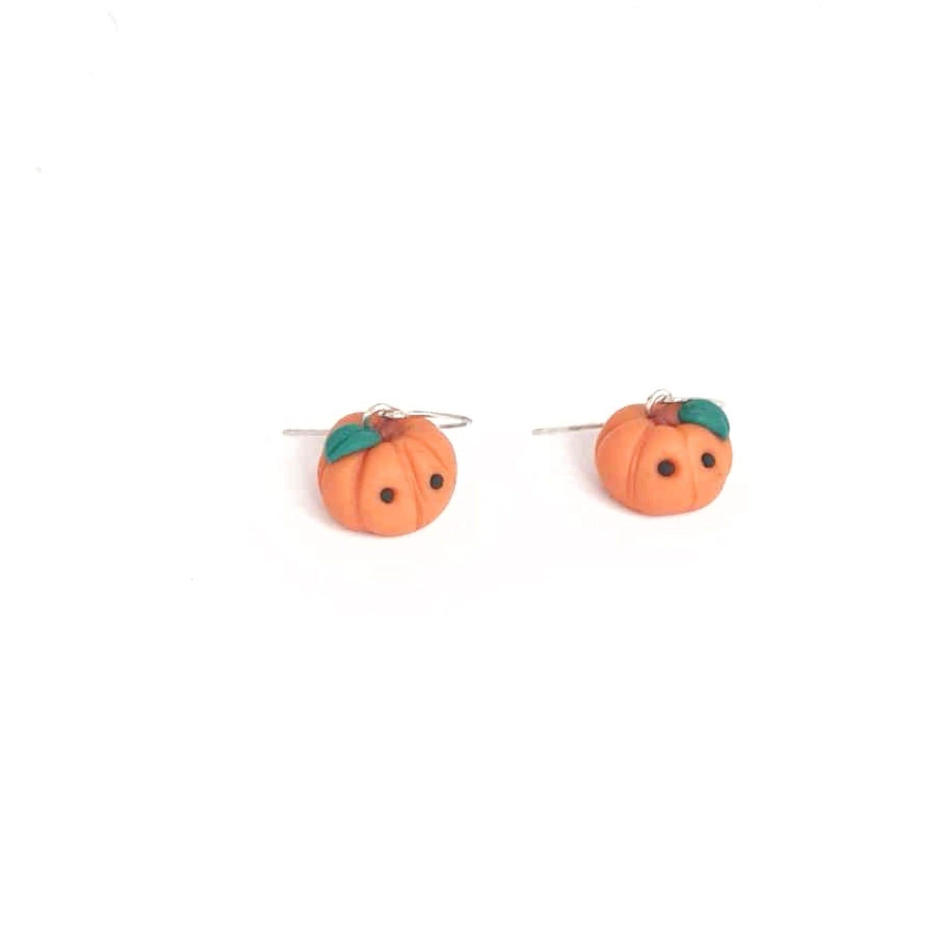 Pumpkin-shaped earrings on a white background
