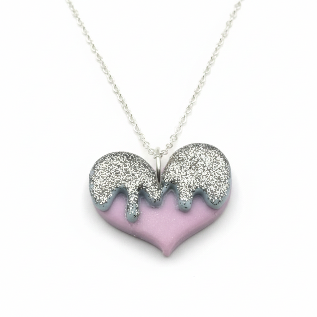 Heart-shaped necklace with glittery silver top and purple bottom on a white background