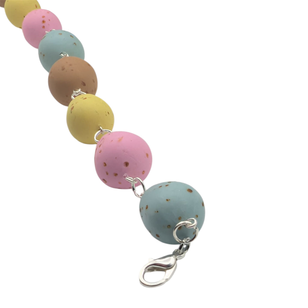 String of faux mini eggs on silver chain on white background 
