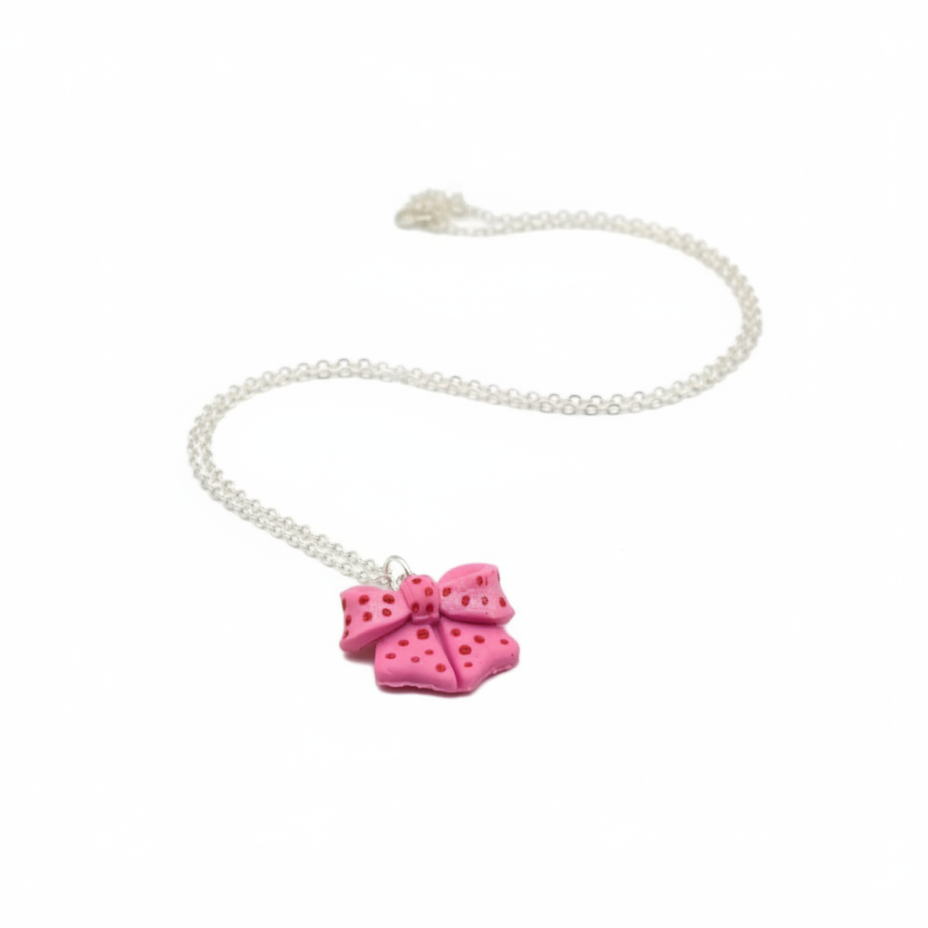 Pink bow jewellery set with silver chain on white background 