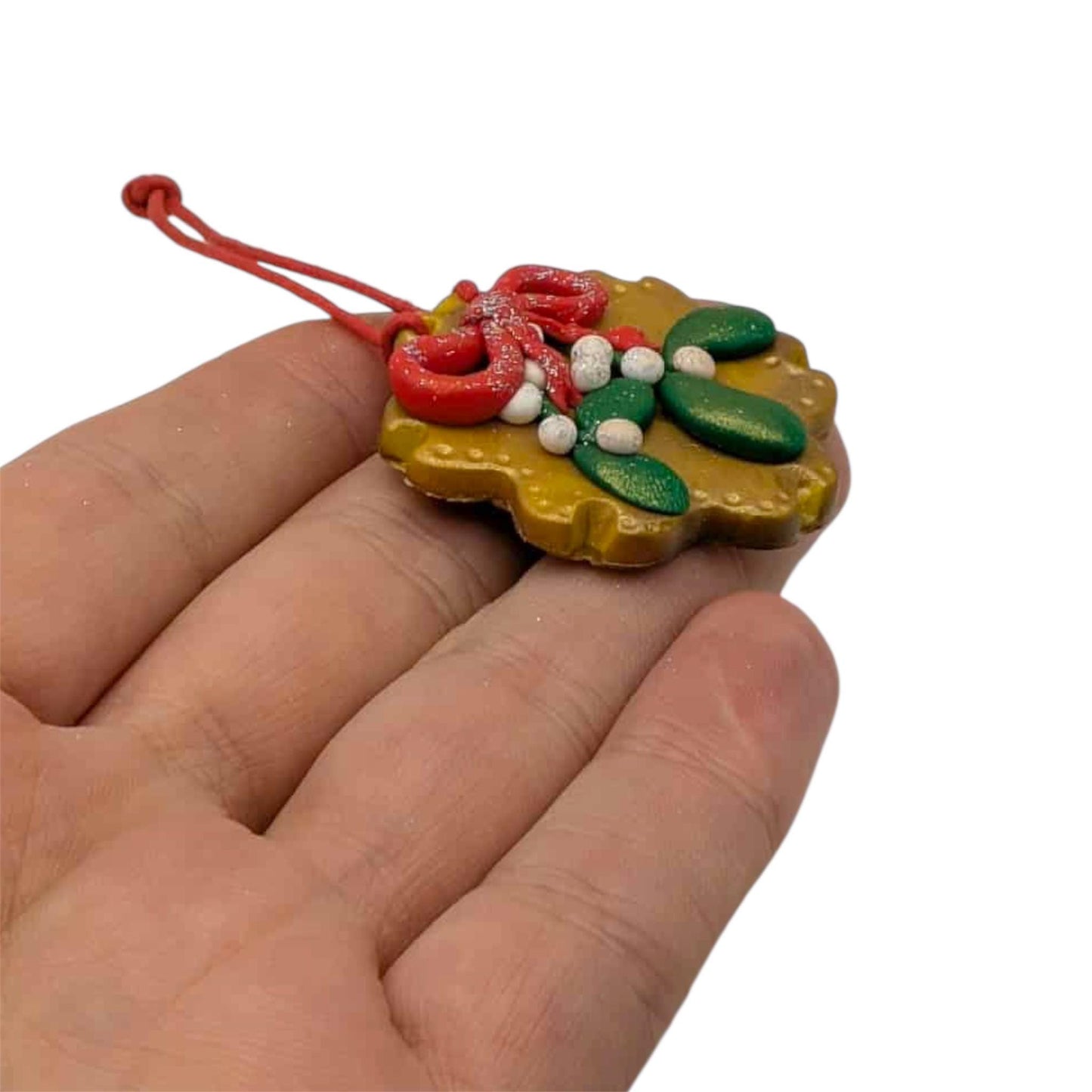 Decorative Christmas ornament held in a hand on a white background