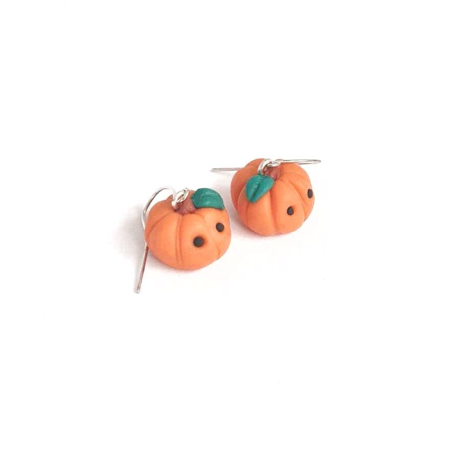 Pumpkin-shaped earrings on a white background