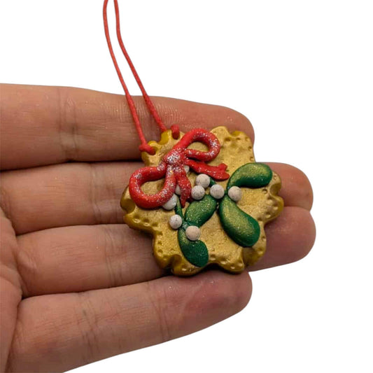 Hand holding a small decorative item with red, green, and yellow colors on a white background