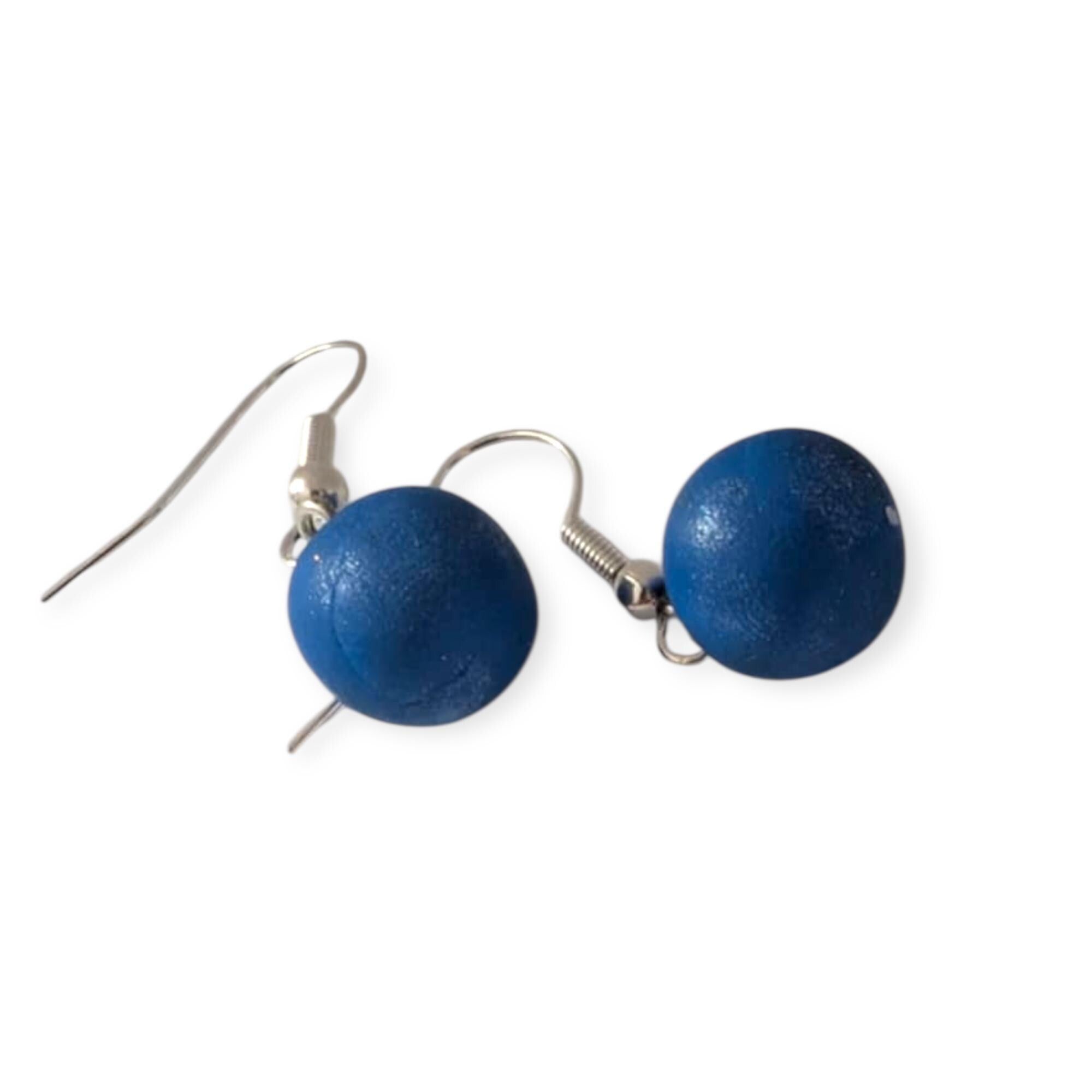 Pair of blue spherical earrings on a white background
