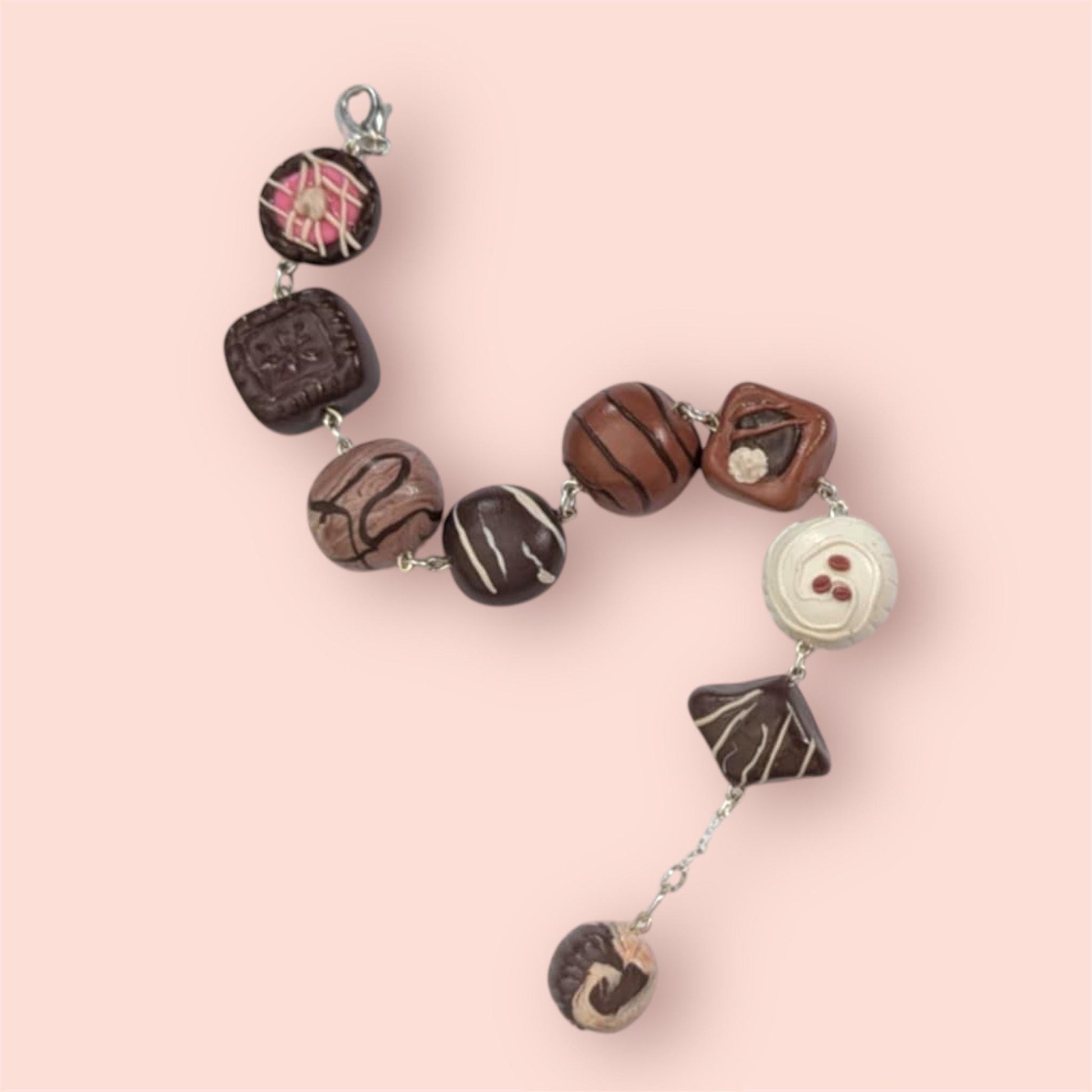 Bracelet with chocolate-themed beads on a pink background