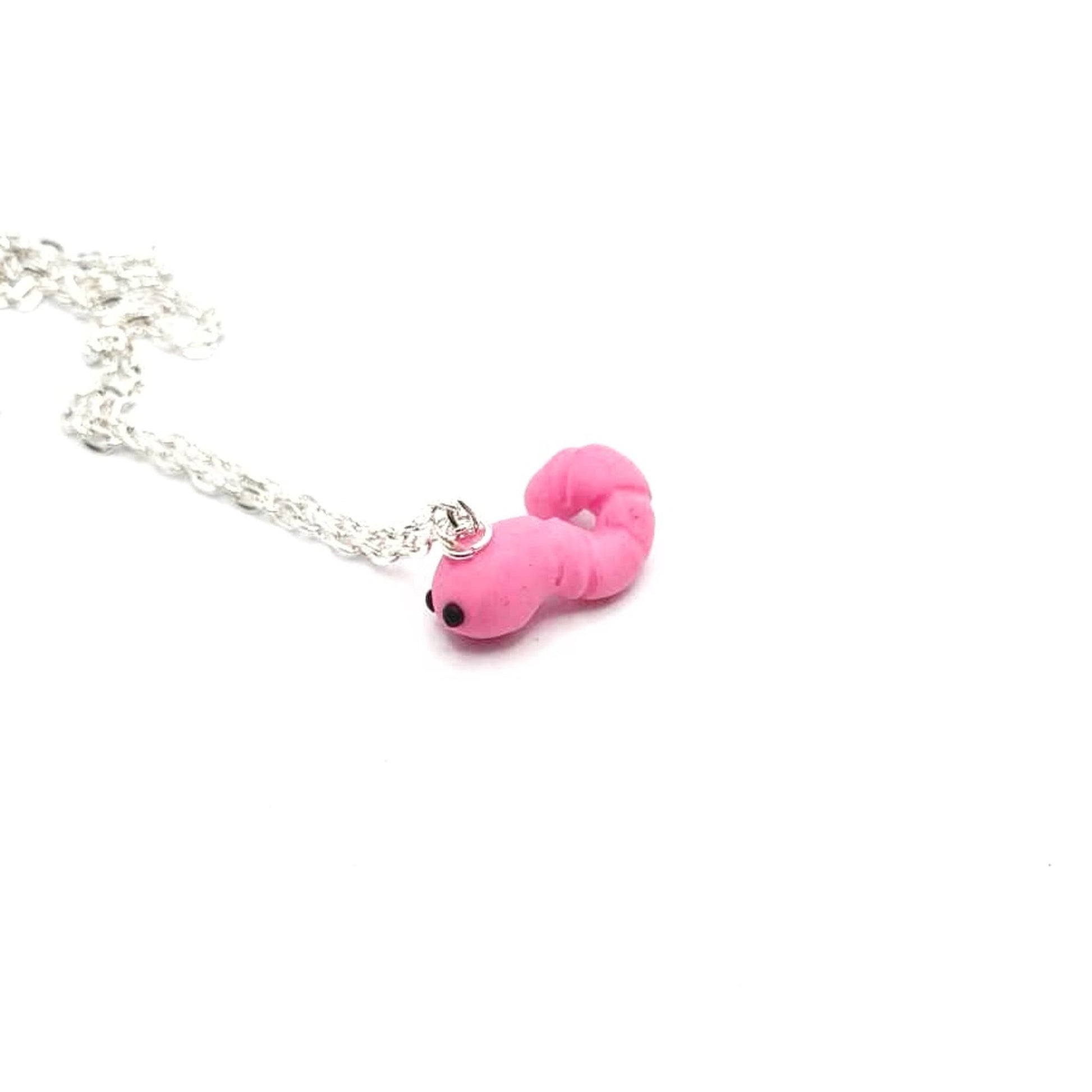 Pink worm-shaped pendant on a silver chain against a white background