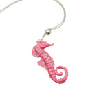 Pink sparkly seahorse pendant necklace with 18-inch silver chain on white background