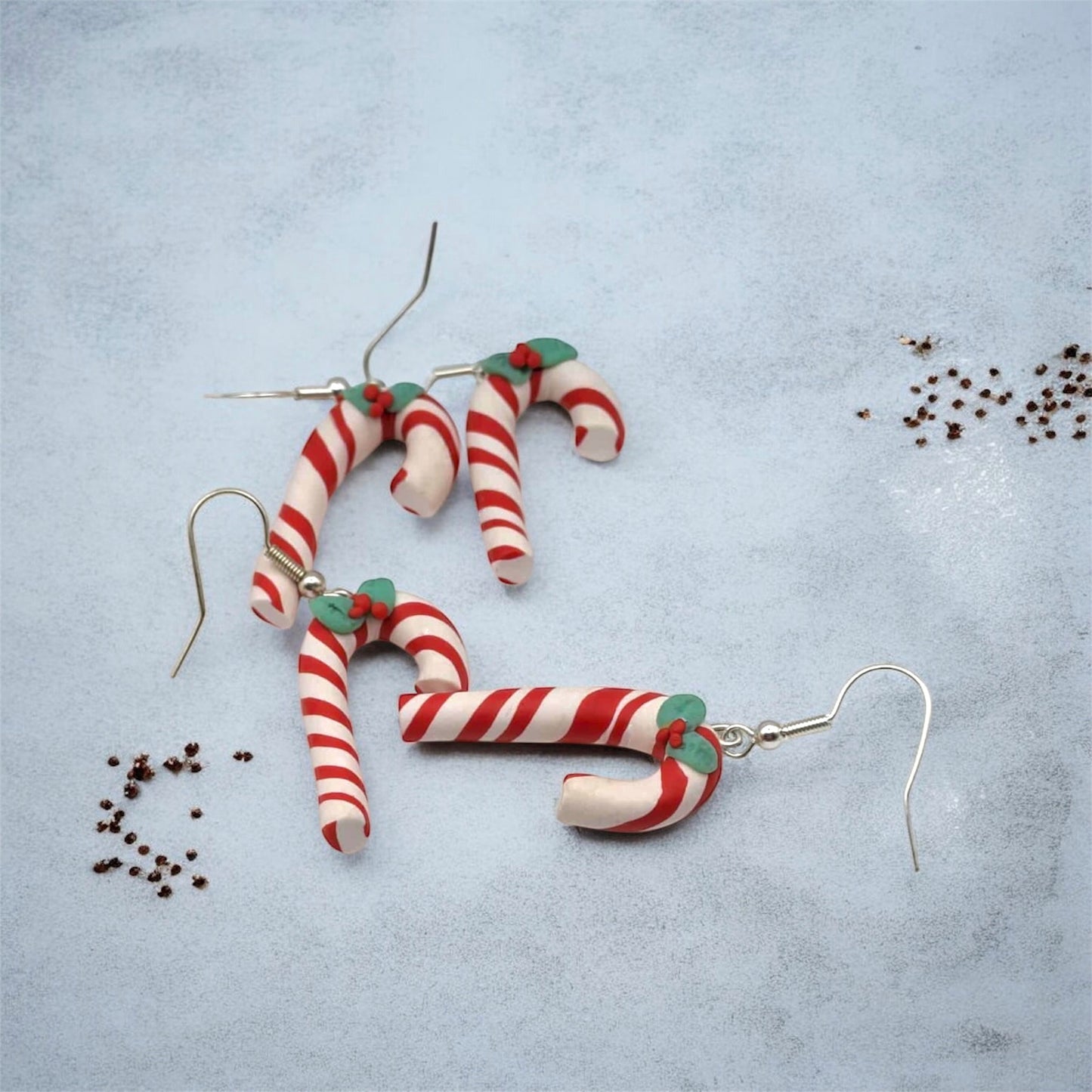 Candy cane-shaped earrings on a light blue background